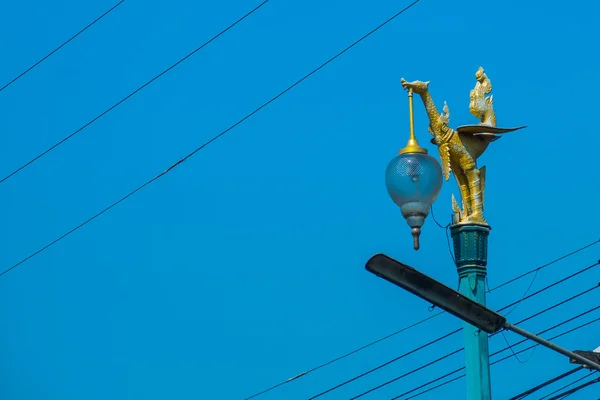 Farola aislada en el cielo azul. La escultura dorada de un pájaro. Tailandia . — Foto de Stock