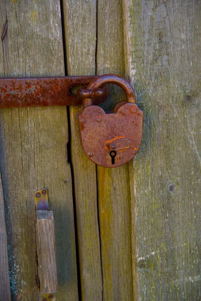 Serratura arrugginita su porta di legno — Foto Stock