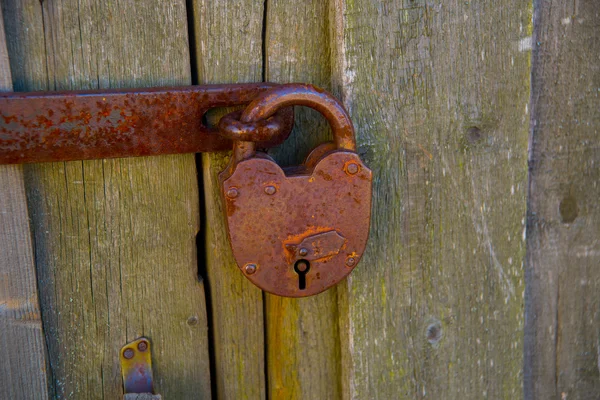 Serratura arrugginita su porta di legno — Foto Stock