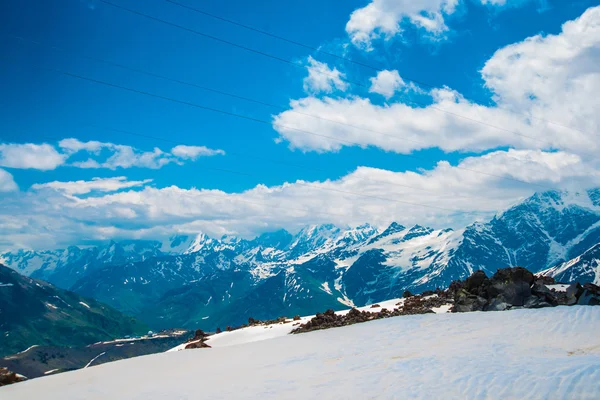 Snö på bergen mot den blå himlen i molnen. Elbrus regionen. Kaukasus. — Stockfoto