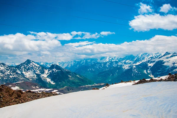 Neve sulle montagne contro il cielo blu nelle nuvole.La regione dell'Elbrus. . — Foto Stock