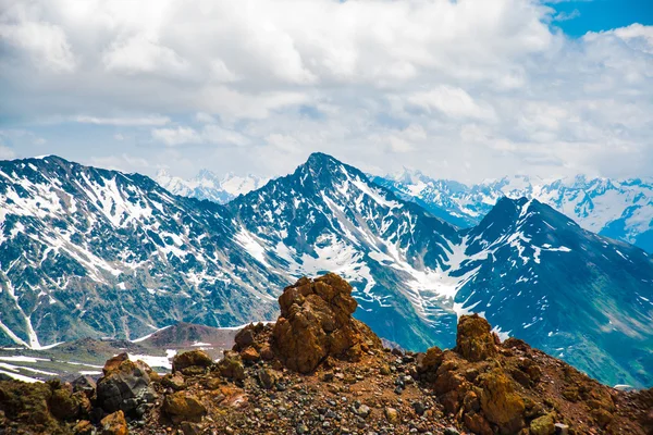 Neve sulle montagne contro il cielo blu nelle nuvole.La regione dell'Elbrus. . — Foto Stock