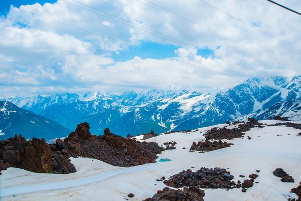 Snö på bergen mot den blå himlen i molnen. Elbrus regionen. Kaukasus. — Stockfoto