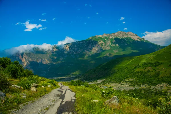 Montañas contra el cielo el verano.Camino.El Cáucaso. .Rusia . — Foto de Stock