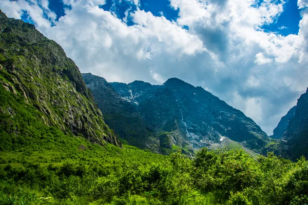 Belas montanhas contra o céu azul brilhante nuvens brancas, o verão.O Cáucaso. .Rússia . — Fotografia de Stock