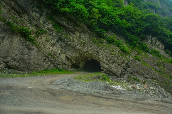 The entrance to the cave.Mountains in the clouds.The Caucasus. .Russia. — Stock Photo, Image