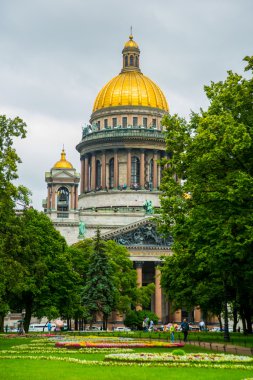 Yeşil ağaçlar arka plan üzerinde onun altın kubbesi ile St. Isaac's Cathedral.