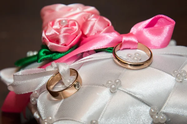 Dois anéis de casamento jazem na almofada — Fotografia de Stock
