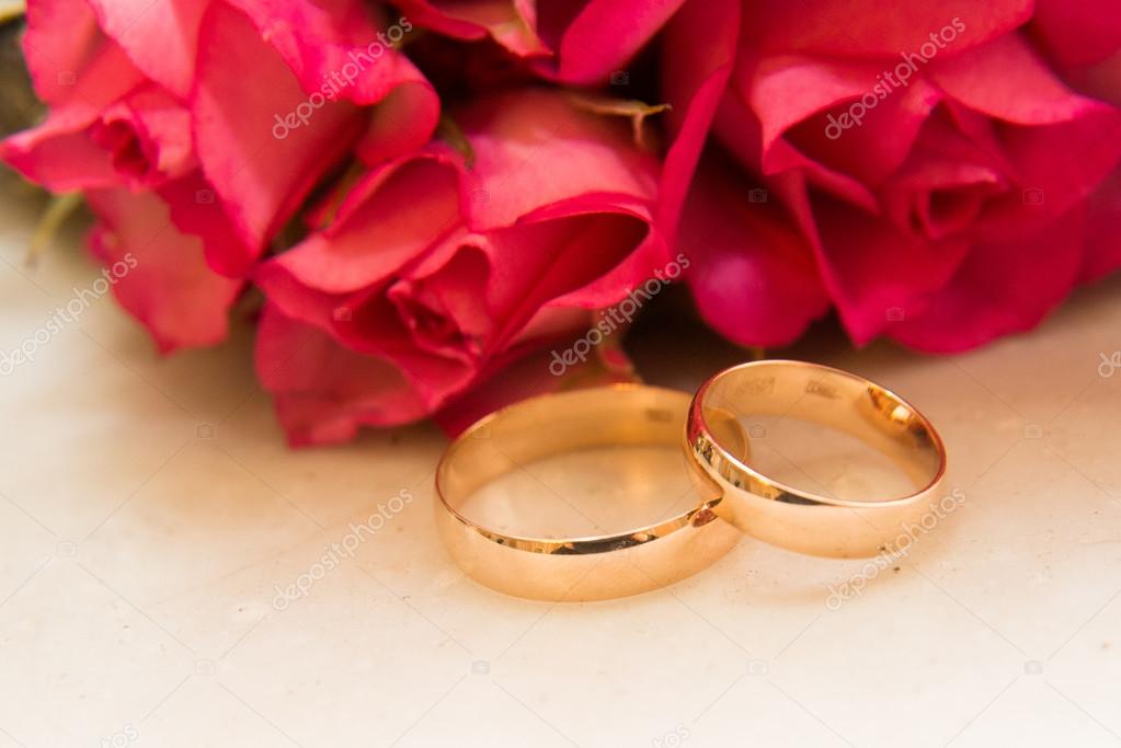 Two wedding rings, red roses