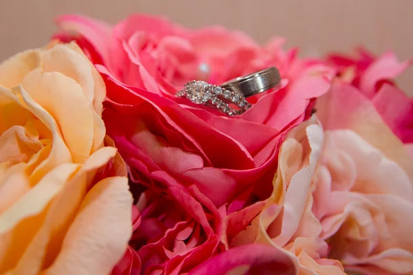 Wedding rings, red flowers — Stock Photo, Image