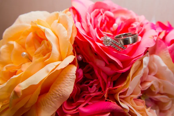 Wedding rings, red flowers — Stock Photo, Image