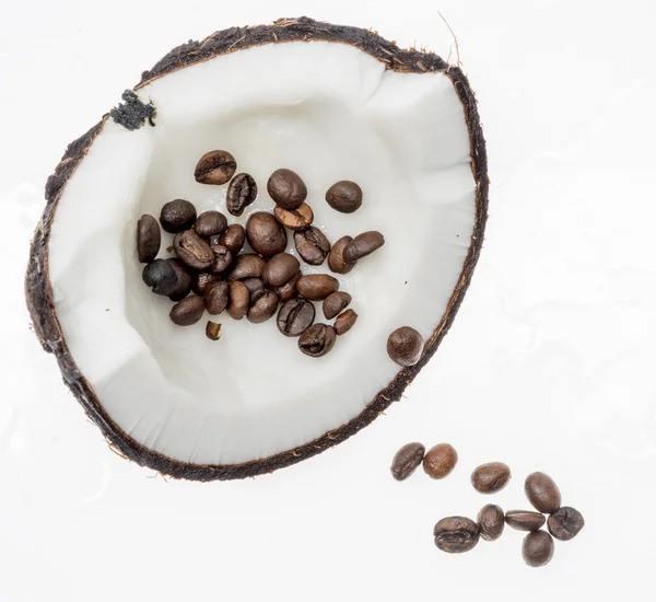 Grãos de café torrados em coco fresco, isolados em branco Fotografia De Stock