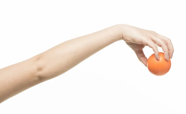 Женская рука с оранжевым губчатым мячом — стоковое фото