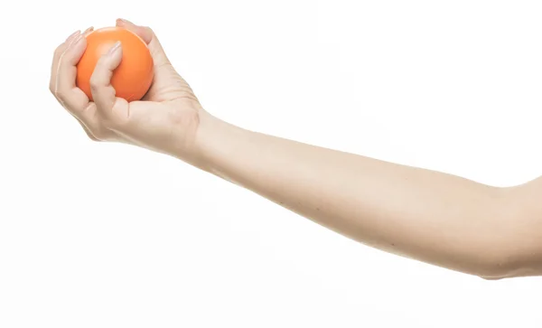 Женская рука с оранжевым губчатым мячом — стоковое фото