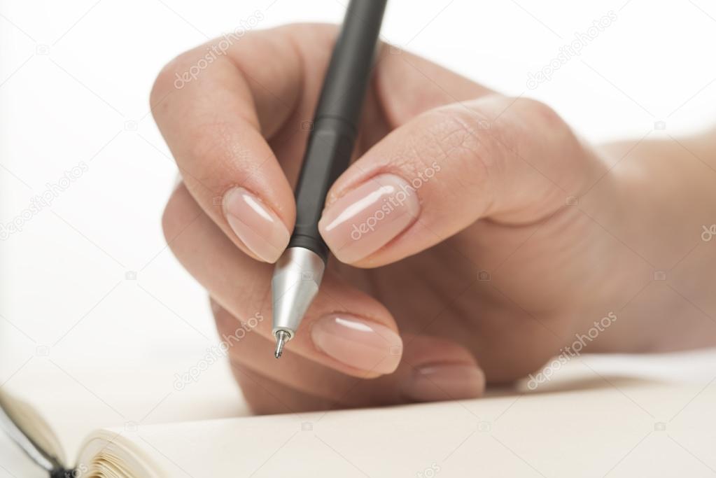 Female hand writing in notebook