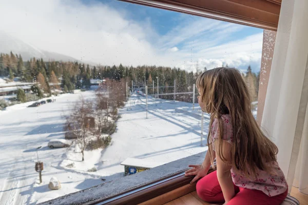 Kız bir pencereden kış gününde