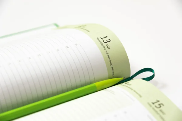 Grünstift auf einem Kalenderbuch — Stockfoto
