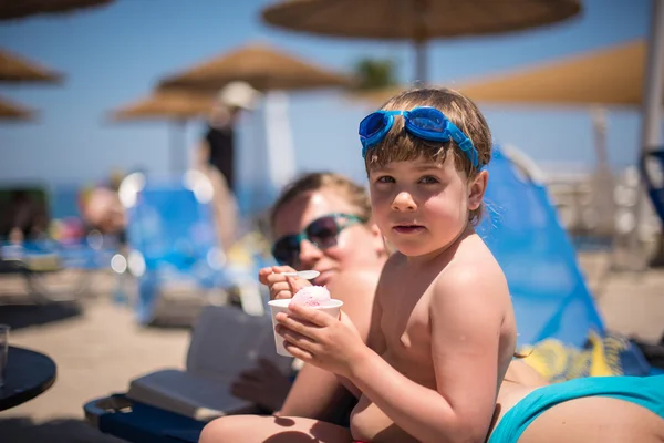 Little girl having ice creams at the outdoor swimming pool