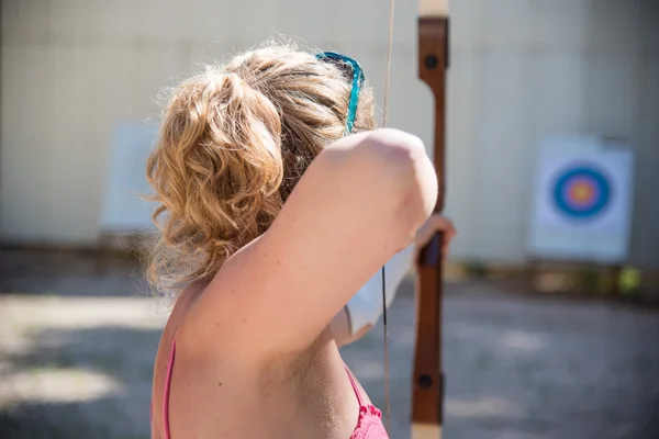 Young woman aiming with a bow — Stock Photo, Image