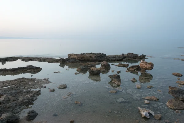 在雾蒙蒙的夜晚, 浅海中的砂岩岩石 — 图库照片