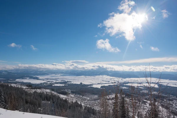 Прекрасное солнце светит, хотя облако над долиной покрыто снегом. — стоковое фото