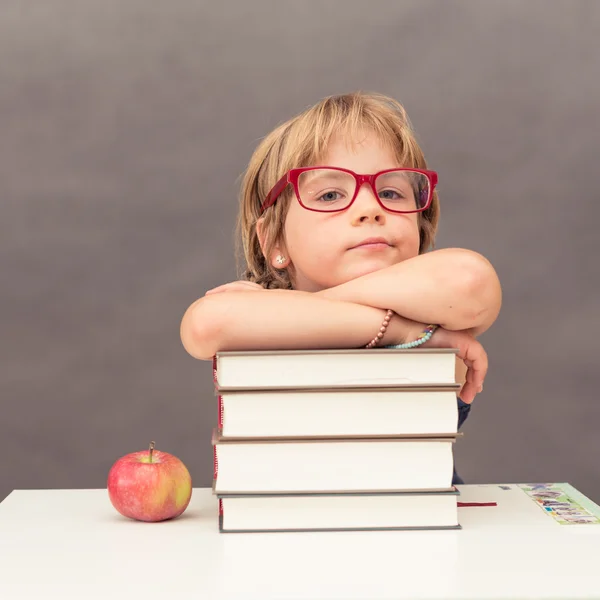 Bir kitap yığını eğilerek kız öğrenci