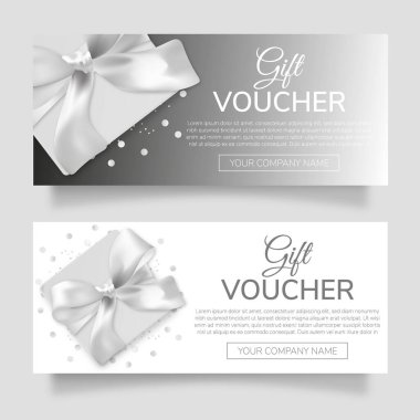 Gri bir arka planda gümüş yay ve kurdeleli bir hediye çeki ve mesajın için bir yer..