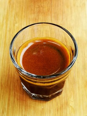 Ahşap masadaki camda duble espresso shot 'ı yakın çekim..