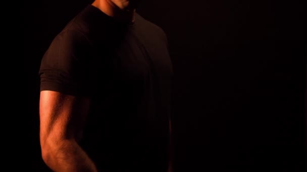 黒の背景にダンベル カールをやって筋肉ボディービルダー — ストック動画
