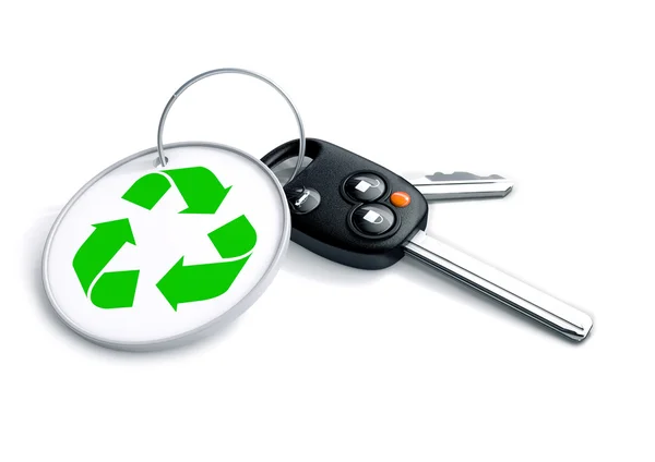 Set of car keys with keyring and recycle symbol. Concept for recycling of vehicles or creation of hybrid clean energy and green powered transportation and cars. — Stockfoto