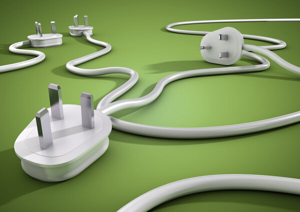 Electical cables and plugs lay on a green smooth surface and overlap each other. Concept for electricity and power usage by consumers.