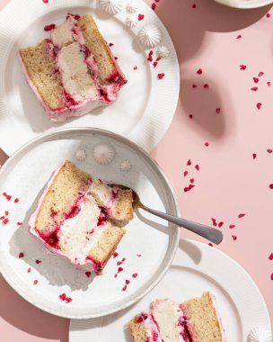 Pembe arka planda vişneli ve hindistan cevizli kek, sert ışık