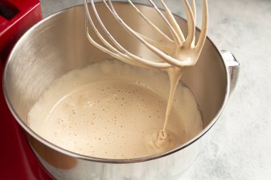 Karıştırıcının kasesinde şekerle yumurta çırpmak, kadın yumurtalara şeker ekler. Ev yemeği.