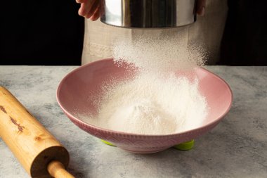 Aşçı kadın un eleme yapıyor. Ev kokaini