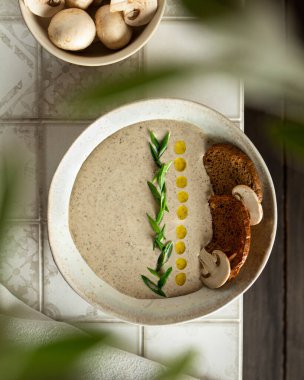 Şampiyonların kremalı çorbası fayanslarla döşenmiş, düzlüklerde bitkiler var.
