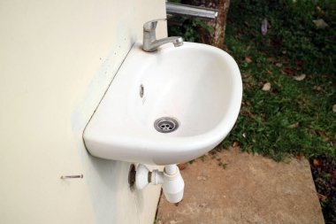 Duvardaki fotoğrafta beyaz bir leğen var.