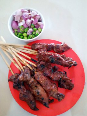 Kırmızı tabakta on tane sığır eti sateni.