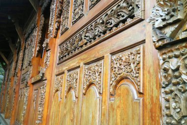 Evin duvarları ahşap oyma fotoğrafından yapılmıştır.