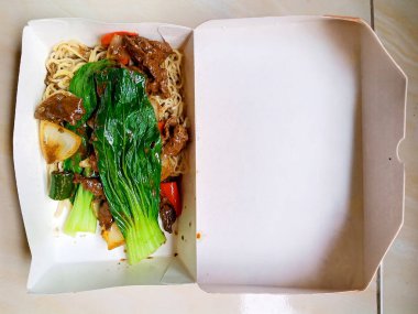 Hardal yapraklı erişte, karton kutuda.