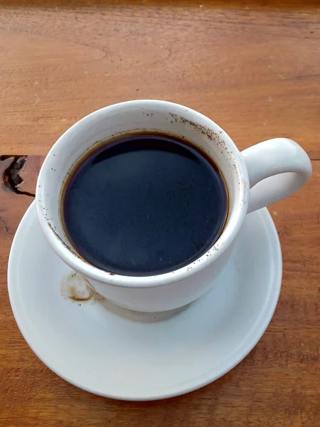 Una Taza Café Negro Una Foto Mesa Madera — Foto de Stock