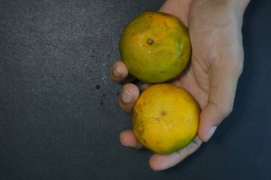 Siyah arkaplan fotoğrafında iki sarı portakal.