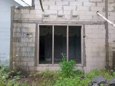 Açık beton duvarları ve pencere çerçevesi olan terk edilmiş tamamlanmamış bina.