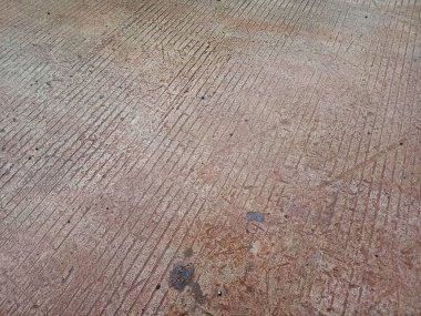 Yıpranmış beton kaldırımı paralel oyuklar, lekeler ve ince toprak tonları ile kapatın, inşaat veya kentsel temalar için soyut dokulu bir arka plan oluşturur.