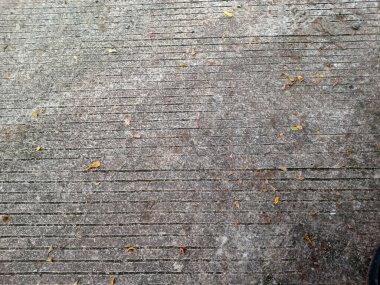 Yıpranmış beton kaldırımlar paralel oyuklar ve dağınık kuru yapraklar, tepeden aşağı görünüm, kopyalama alanı olan kentsel desenli arka plan.