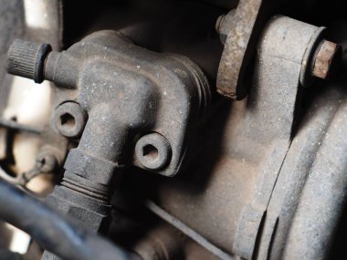 1970 mahsulünden kalma eski, pis, kaba, orta boy dizel kamyonet motoru kaputun altında eskimiş metal plastikler ve lastik parçalar var. 