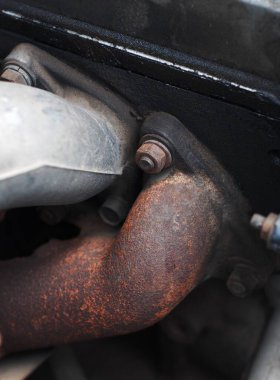 1970 mahsulünden kalma eski, pis, kaba, orta boy dizel kamyonet motoru kaputun altında eskimiş metal plastikler ve lastik parçalar var. 