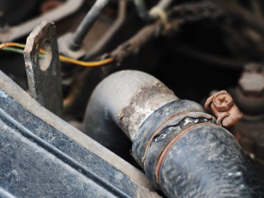 1970 mahsulünden kalma eski, pis, kaba, orta boy dizel kamyonet motoru kaputun altında eskimiş metal plastikler ve lastik parçalar var. 