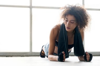 Genç bayan antrenman yapıyor ve esneme hareketleri yapıyor.