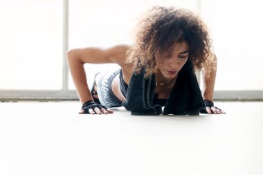 Genç bayan antrenman yapıyor ve esneme hareketleri yapıyor.