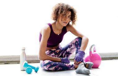 Genç bayan antrenman yapıyor ve esneme hareketleri yapıyor.